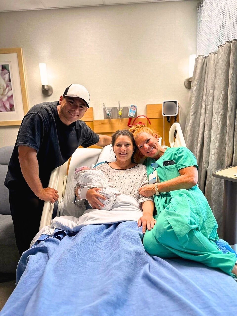 Labor and Delivery nurse Kim Heathcote with happy family and newborn baby after successful hospital birth