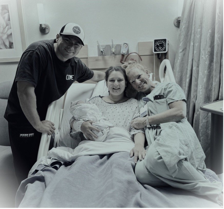 Labor and Delivery nurse Kim Heathcote with happy family and newborn baby after successful hospital birth